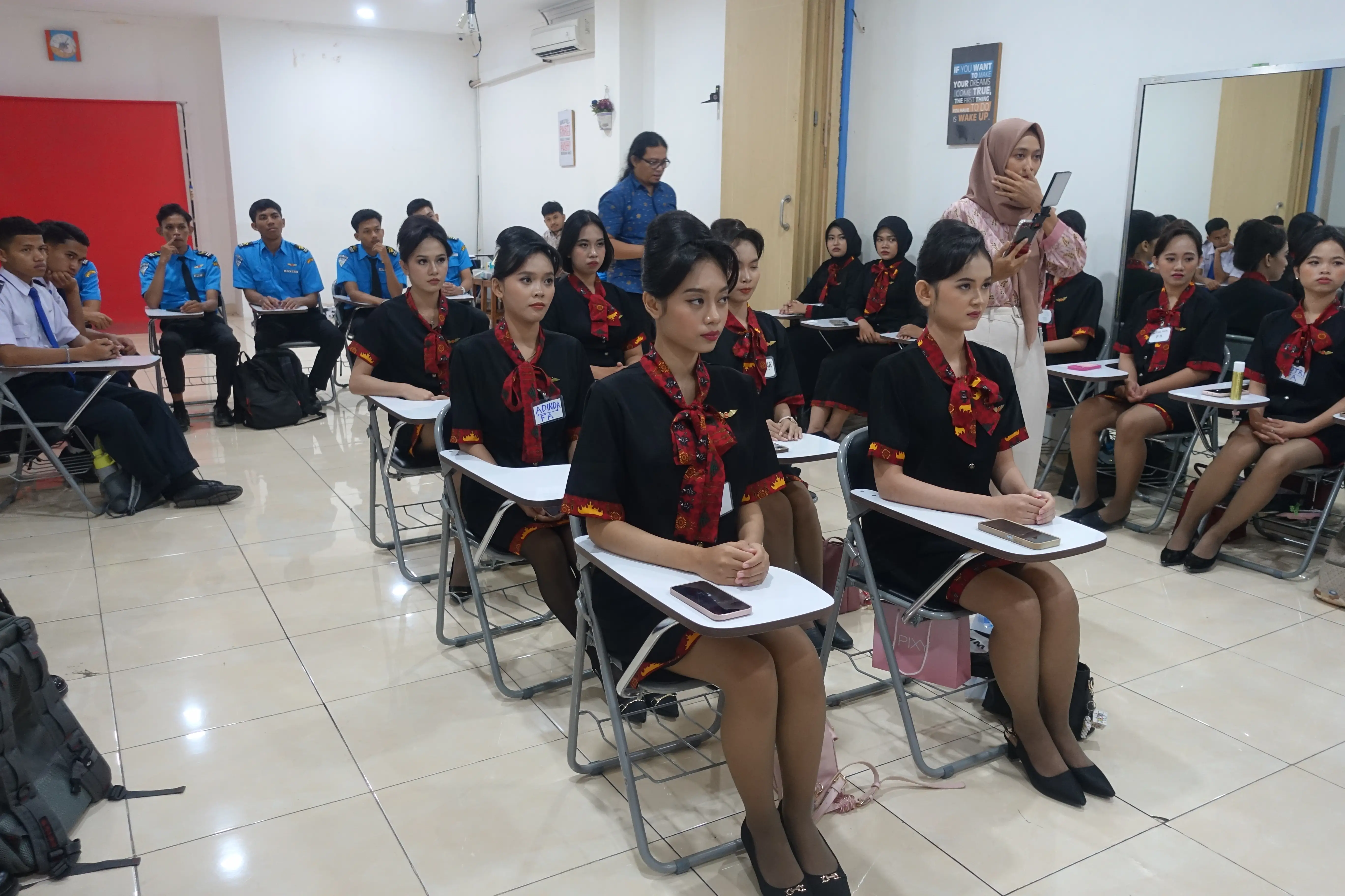 Pelatihan siswi pramugari di kelas akademi penerbangan.